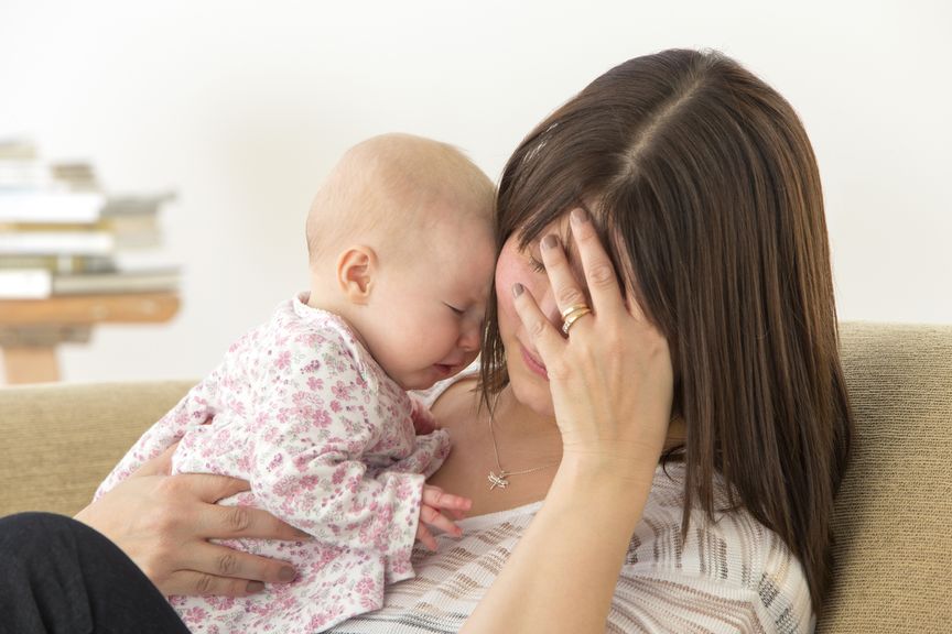 Erschöpfte Mutter mit weinendem Baby