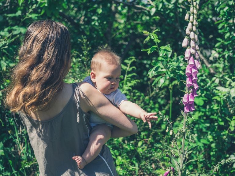 Baby auf Mutters Arm im Garten