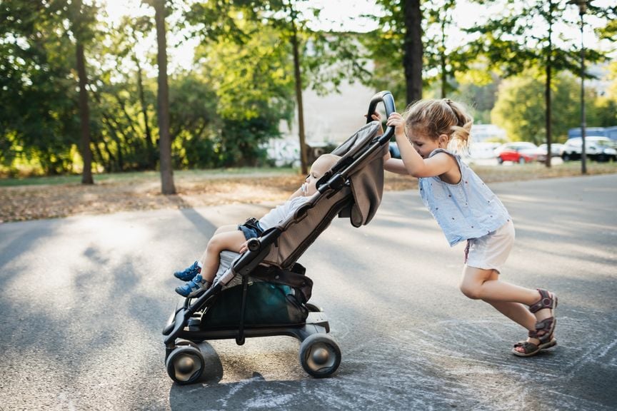 Mädchen schiebt Buggy