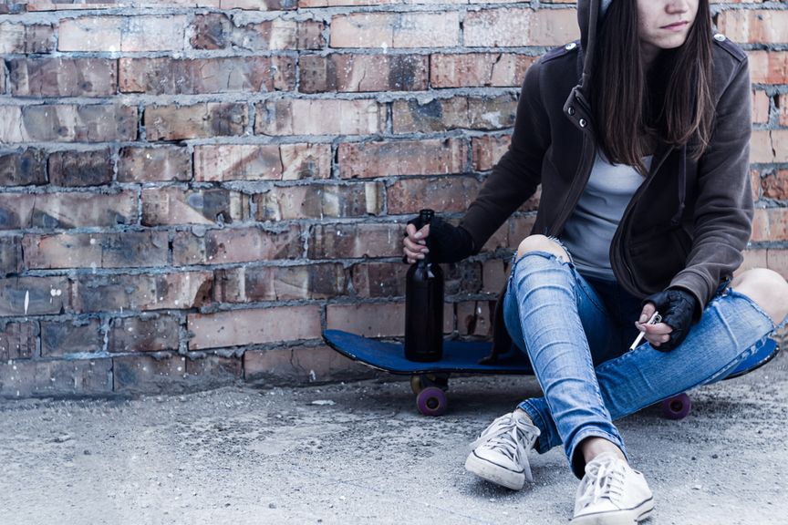 Teenager mit Skateboard, Alkohol und Zigarette