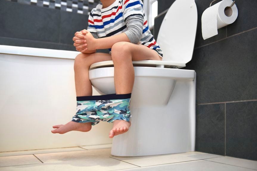 Kind sitzt auf dem WC