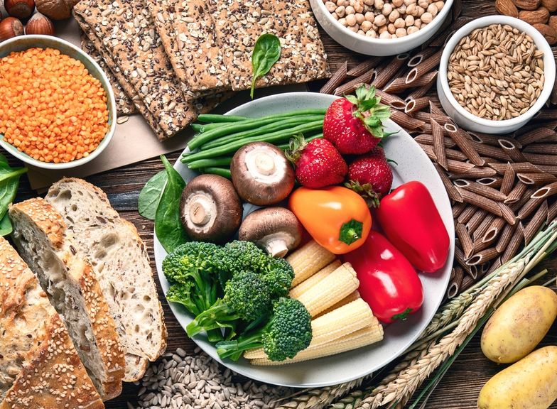 Getreide, Brot, Hülsenfrüchte, Vollkornpasta und Kartoffeln mit Gemüse, Champignons und Erdbeeren auf einem Teller