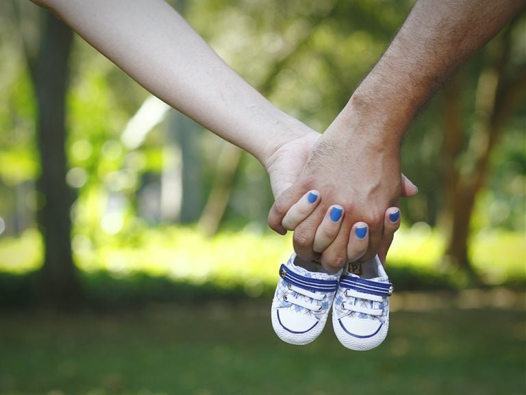 Paar hält Babyschuhe in den Händen