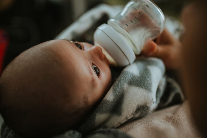 Baby wird mit Schoppen gefüttert