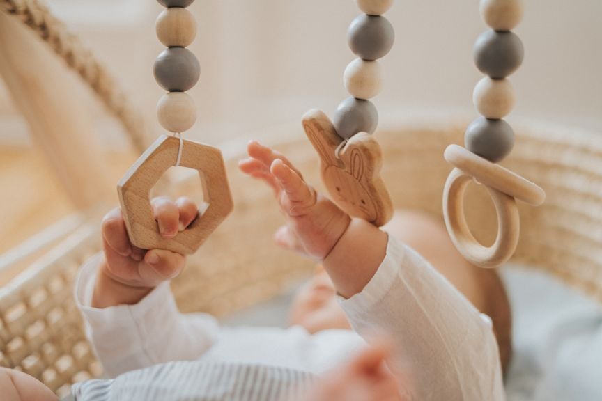 Babyhände greifen nach dem Mobile