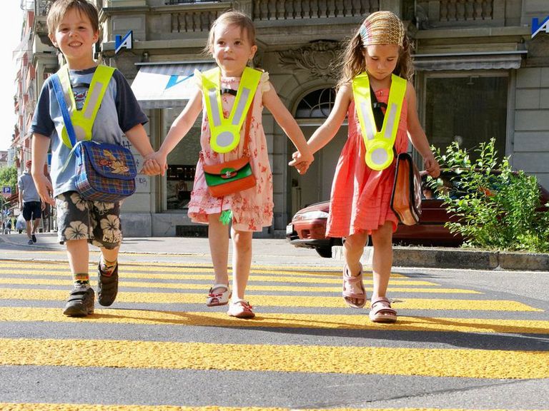 Kinder auf dem Schulweg mit Leuchtweste
