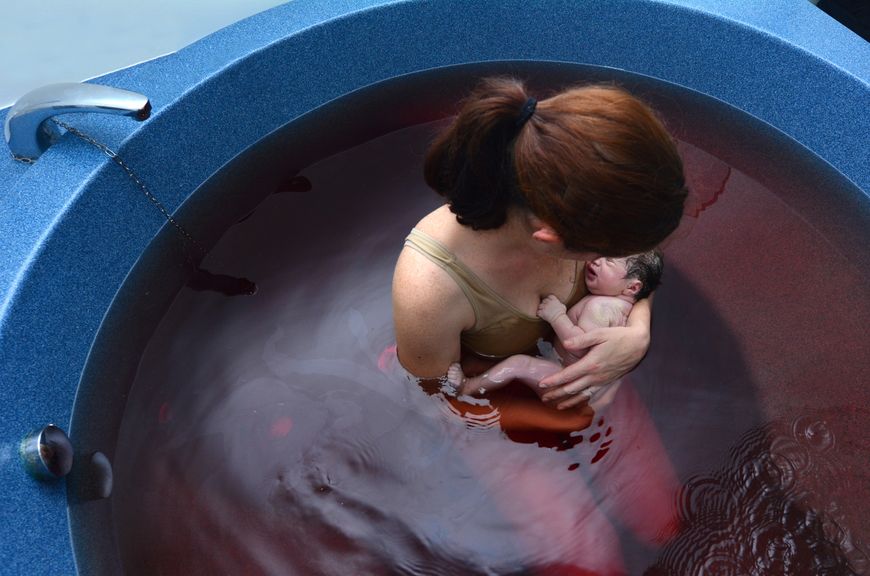 Mutter mit Neugeborenem nach der Wassergeburt