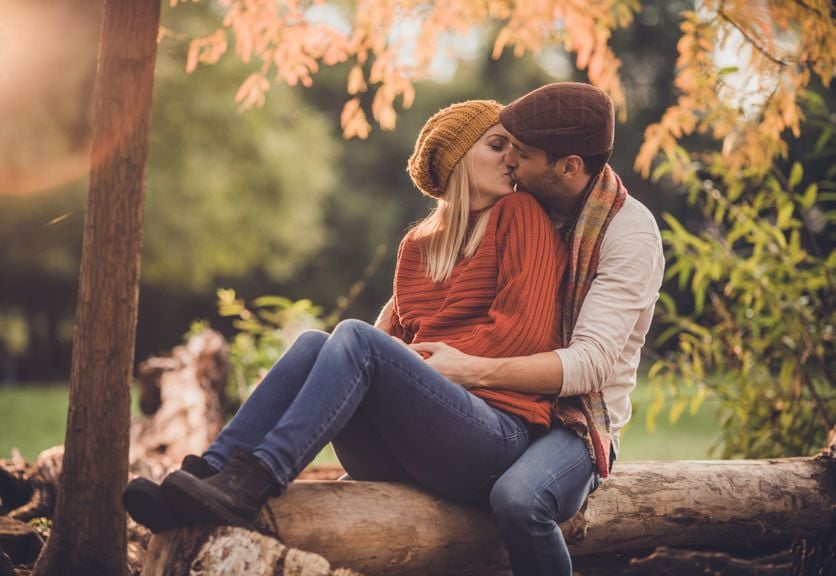 Liebespaar küsst sich im Herbstwald