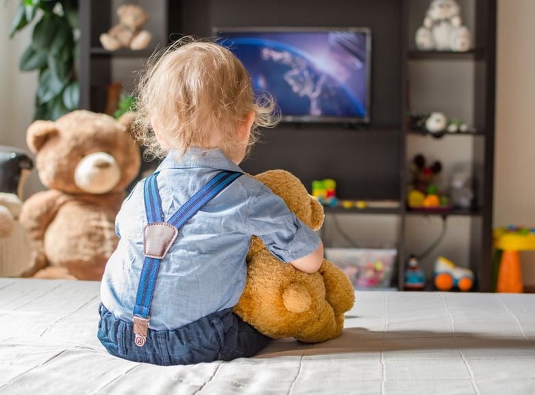 Kind mit Teddies vor dem Fernseher