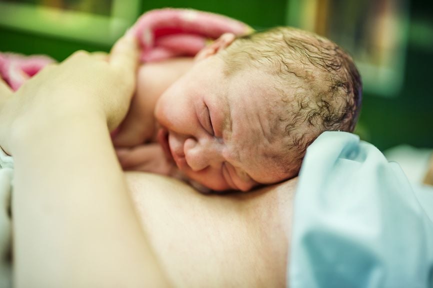 Neugeborenes auf dem Bauch der Mutter