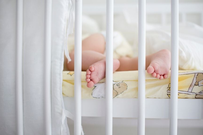 Baby schläft im Gitterbett