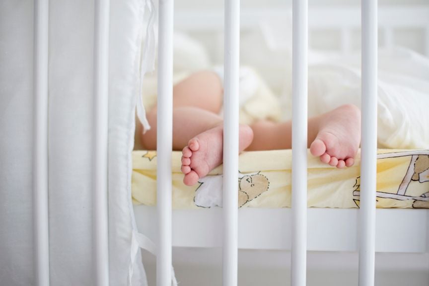 Baby schläft im Gitterbett