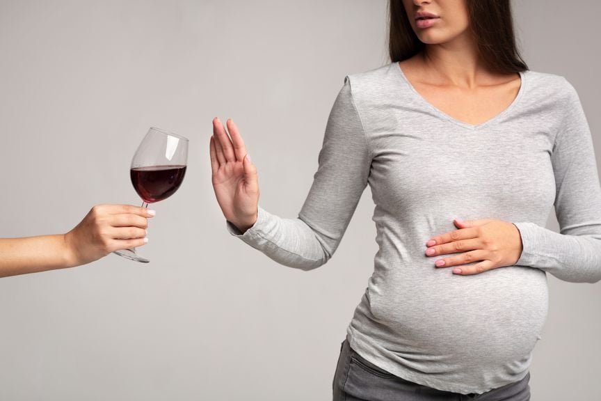 Schwangere lehnt das Glas Rotwein ab