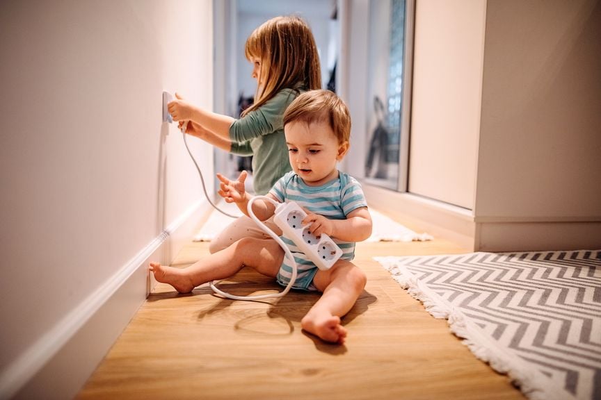 Kinder spielen mit der Steckdose 