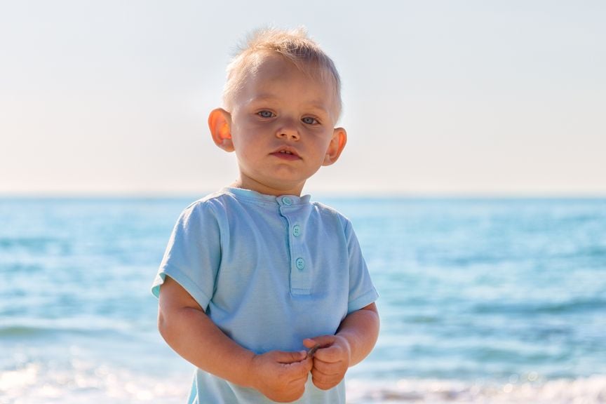 Junge mit abstehenden Ohren am Strand