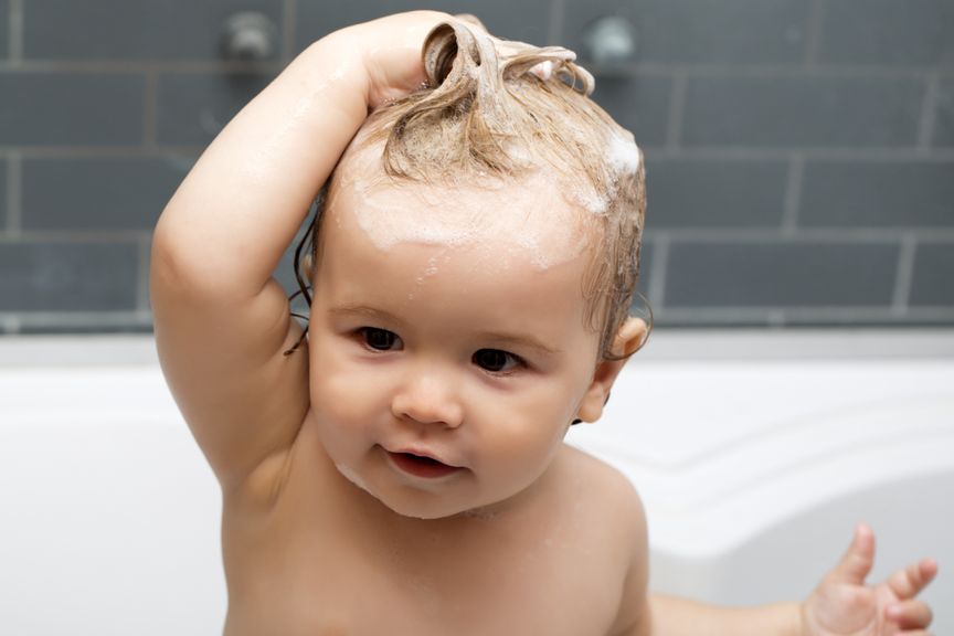 Baby wäscht sich selber die Haare in der Wanne
