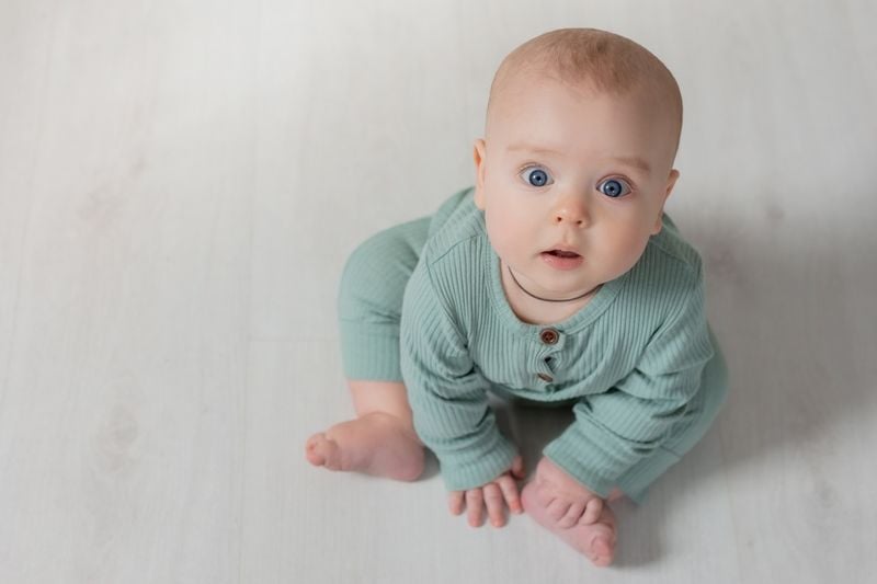 Baby sitzt auf dem Boden