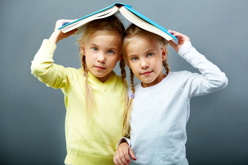 Zwillinge gemeinsam unter einem Buch