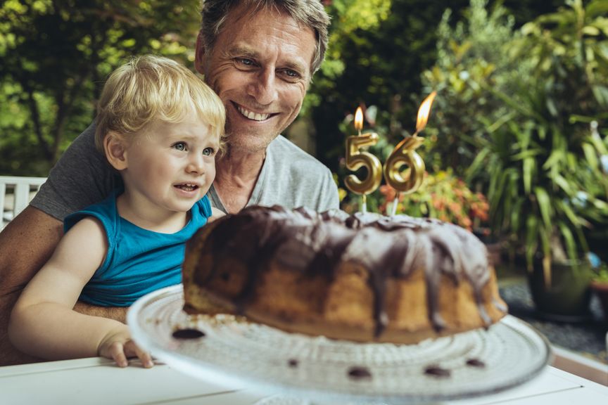 Kind mit Vater und einem Geburtstagskuchen