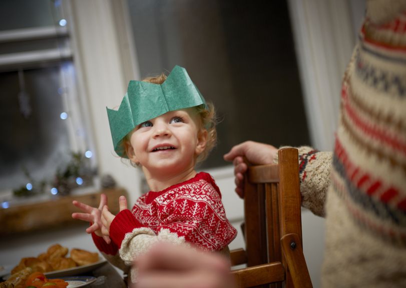 Mädchen mit Krone an Weihnachten am Esstisch