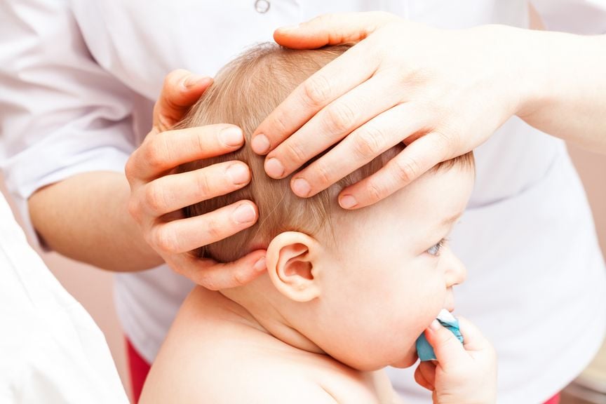 Hände am Kopf des Babys