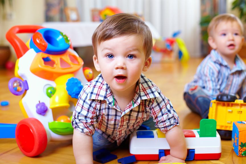 Zwei Kinder spielen auf dem Boden