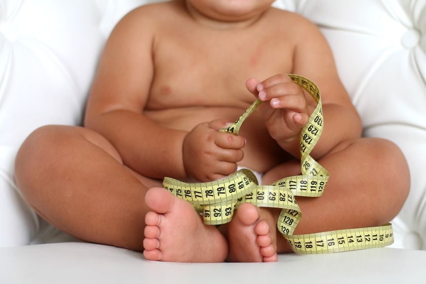 Baby mit Massband in der Hand