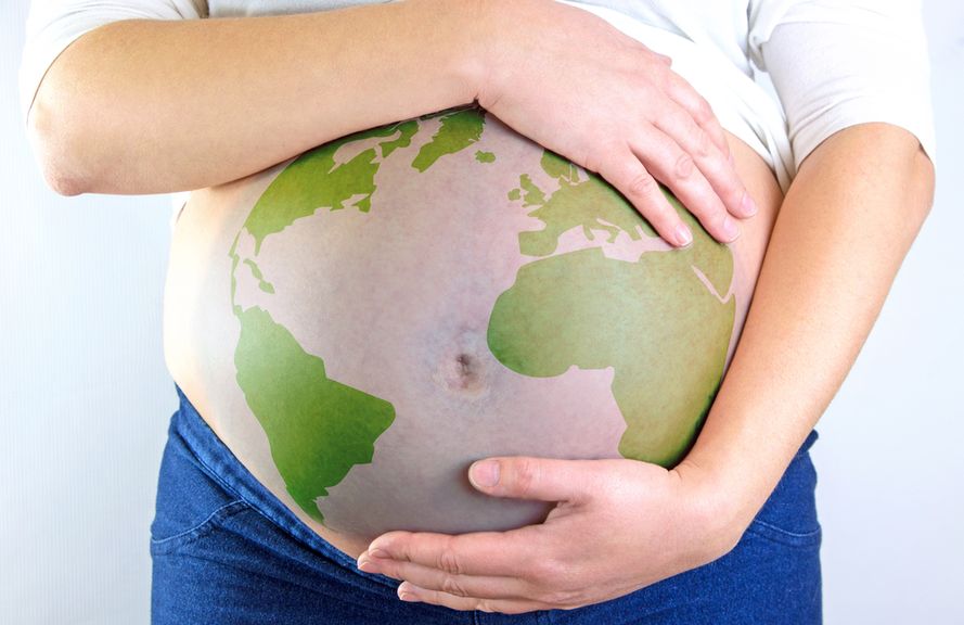 Frau hält ihren schwangeren Bauch, der mit einer Weltkarte bedruckt ist
