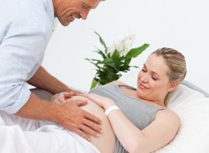 Gynäkologe tastet Bauch der Schwangeren ab