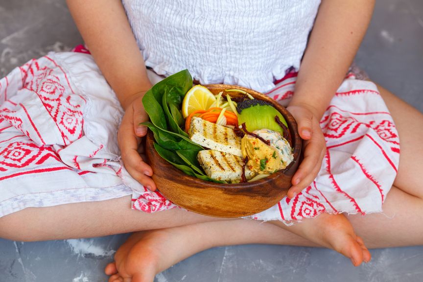 Mädchen mit einer Schale Tofu und Gemüse