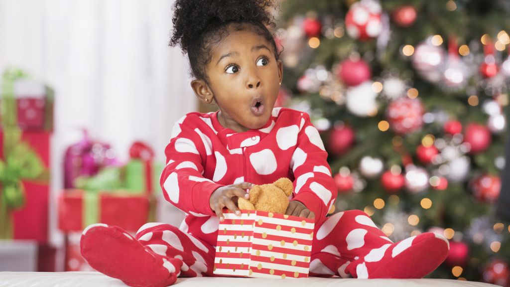 Kleines Kind packt Weihnachtsgeschenke aus