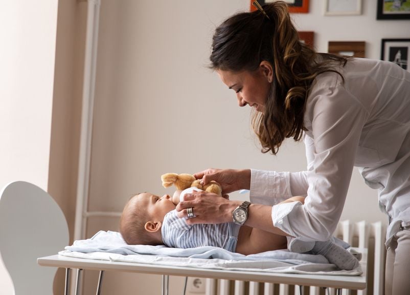 Mutter lenkt Baby mit Teddy ab