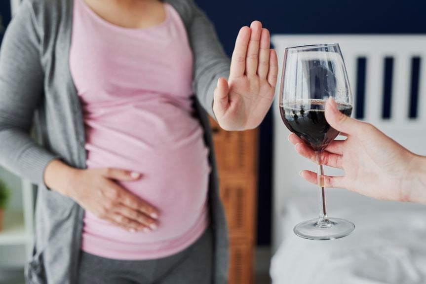 Schwangere weist ein Glas Rotwein zurück