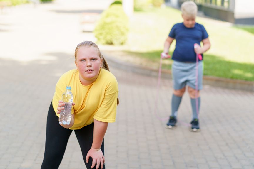 Übergewichtige Kinder machen eine Pause beim Sport
