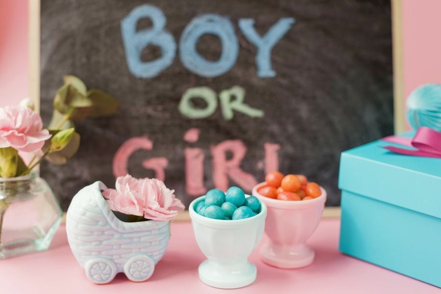 Süssigkeiten und Dekorationen vor einer Tafel mit der Aufschrift "Boy or Girl"