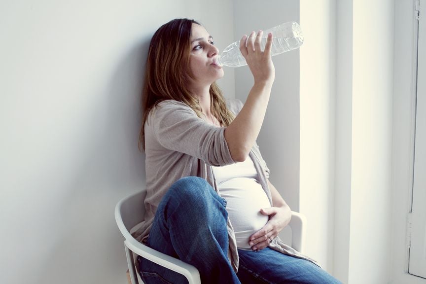 Schwangere trinkt aus der Flasche