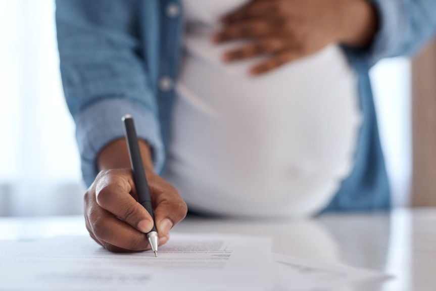 Schwangere Frau unterschreibt einen Vertrag