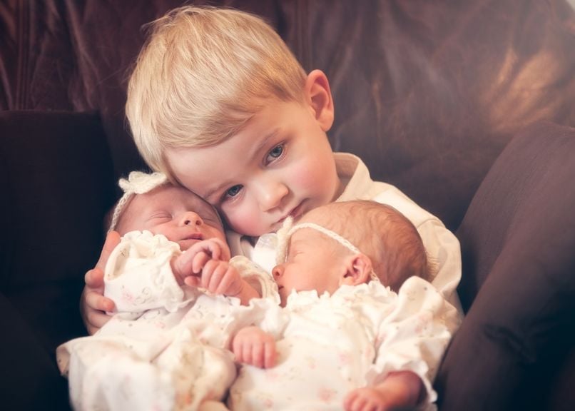 Kind mit neugeborenen Zwillingen
