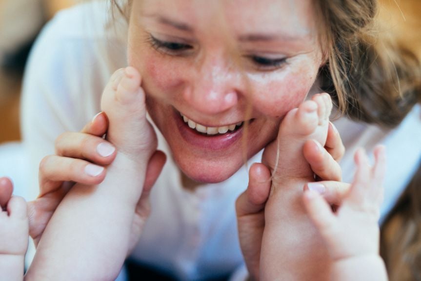 Mutter spielt mit Babyfüssen