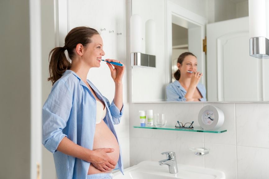 Schwangere putzt sich die Zähne
