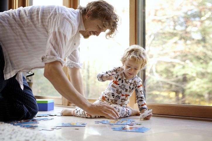 Vater spielt mit Jungen am Boden