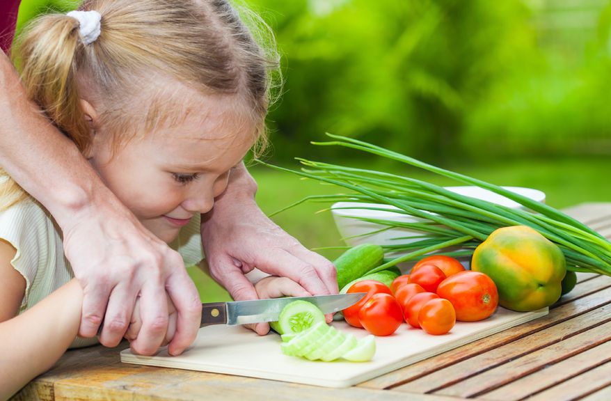 Kind hilft beim Rüsten ,Mädchen beim Gemüserüsten