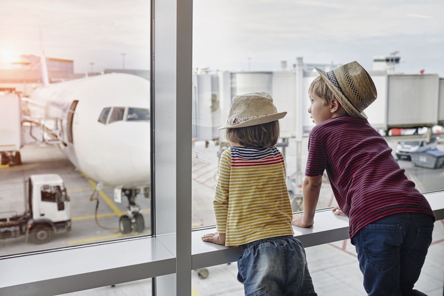 Zwei Kinder bestaunen Flugzeug am Flughafen