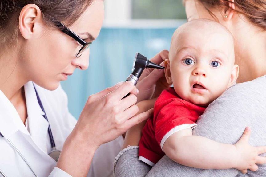 Kinderärztin untersucht das Ohr
