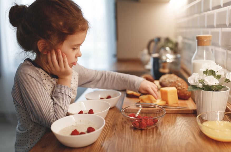 Mädchen richtet in der Küche das Morgenessen