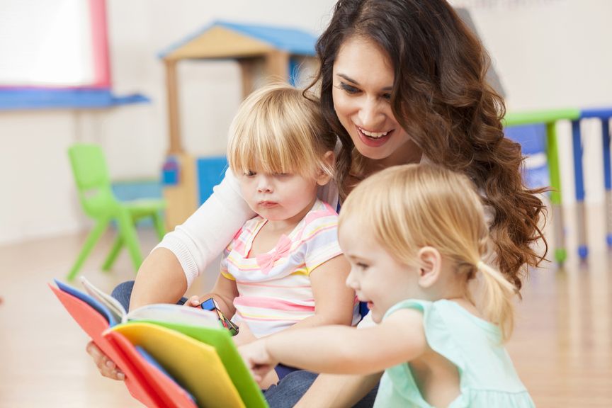 Kinder schauen, mit der Tagesbetreuung, ein Buch an