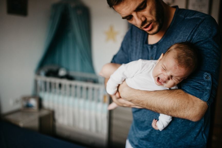 Vater hält sein Baby mit Bauchschmerzen