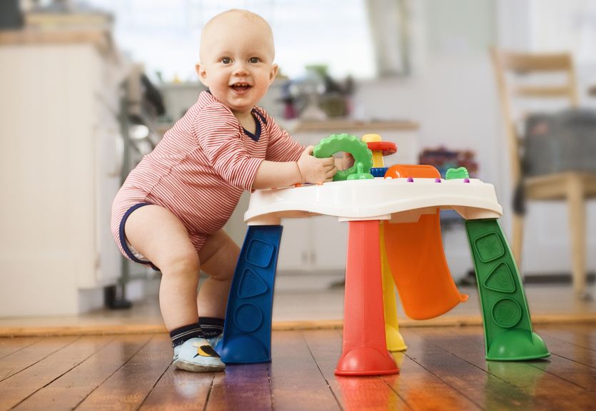 Baby steht am Spieltisch