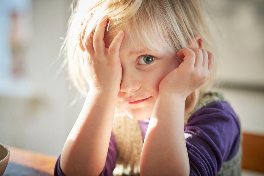 Schüchternes Kind mit halb verdecktem Gesicht