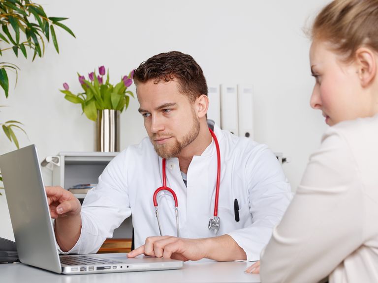 Frau beim Arzt, sie besprechen ihre Werte direkt am Laptop